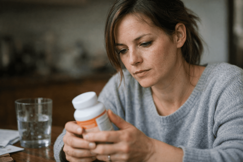 Woman examining thyroid support supplement bottle for informed health decisions